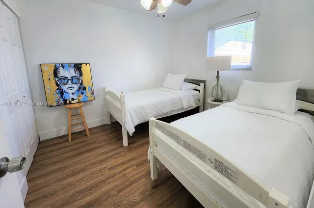 a bedroom with two beds and a desk