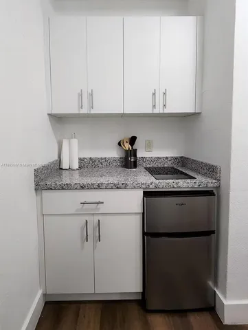 a kitchen with granite countertop white cabinets and a white stove