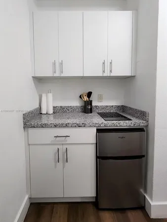 a kitchen with granite countertop white cabinets and a white stove