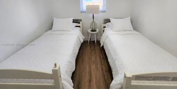 a bed room with two bed and a night stand