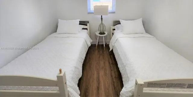 a bed room with two bed and a night stand