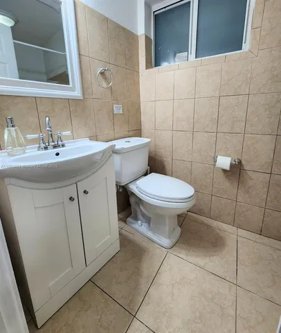 a bathroom with a sink a toilet and mirror