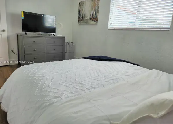 a bedroom with a flat screen tv and a window