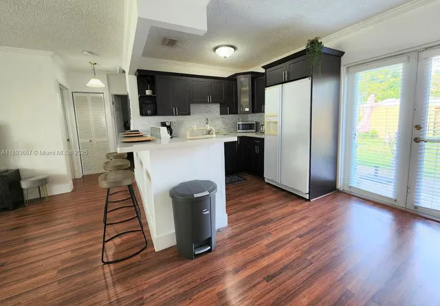a kitchen with stainless steel appliances a refrigerator a sink dishwasher and a stove with wooden floor