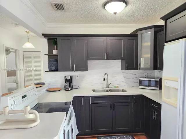 a kitchen with a sink cabinets and appliances
