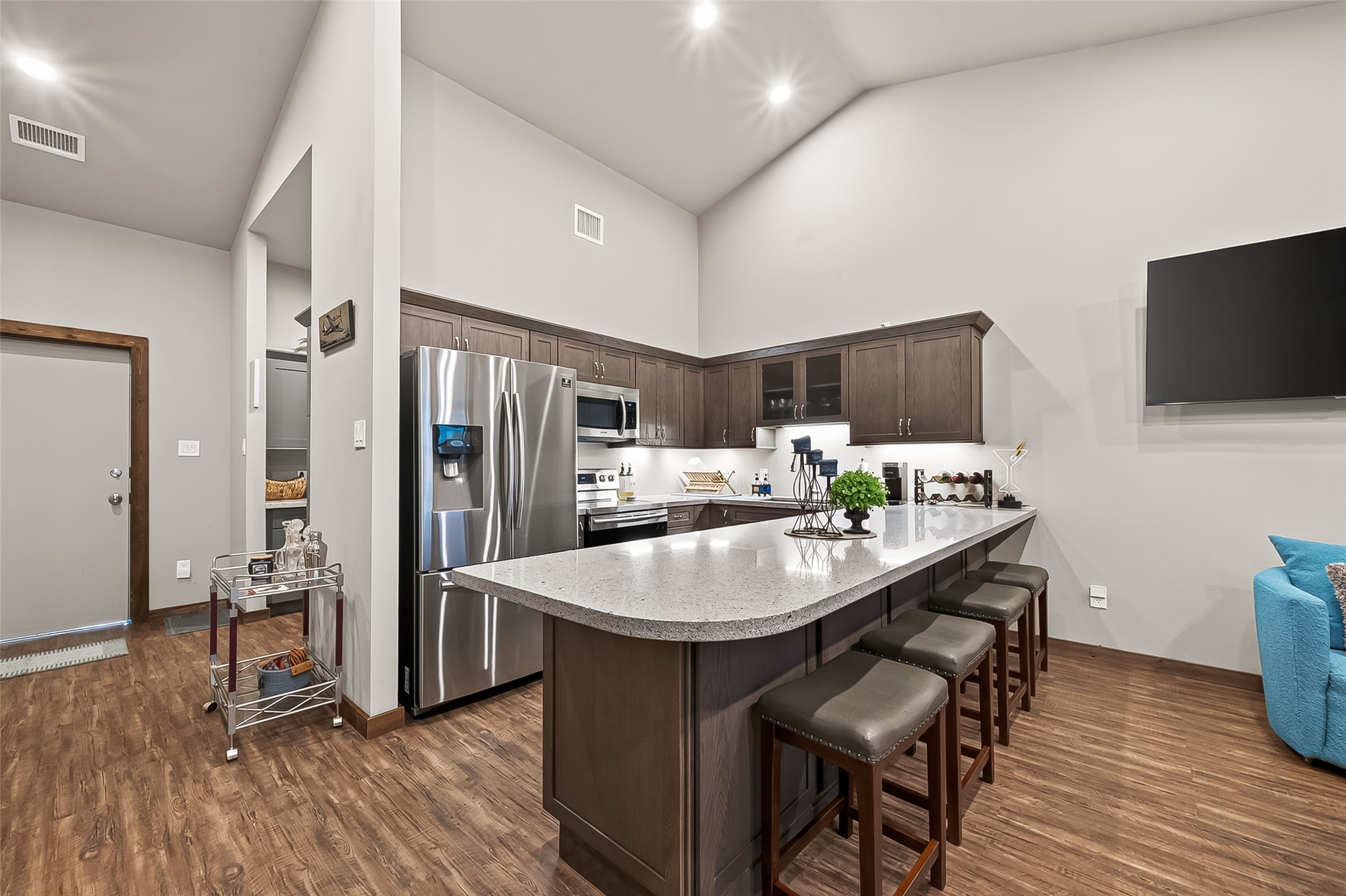 22610 Cessna Road Needville, TX 77461 - Photo 22 of 37 Modern kitchen with sleek stainless steel appliances, dark cabinetry, and a spacious quartz countertop with bar seating for casual dining.