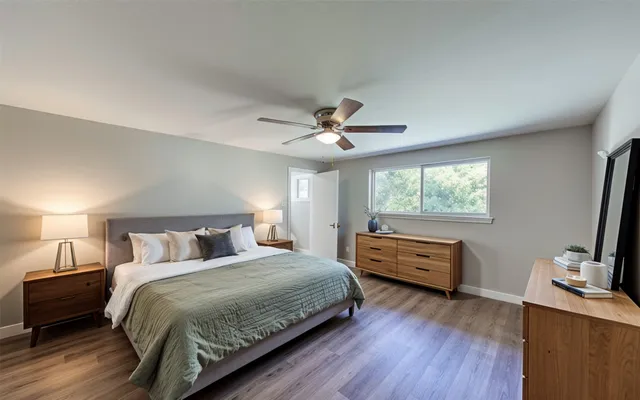a view of an empty room with window and wooden floor