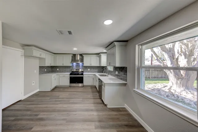 a open kitchen with white cabinets and white appliances
