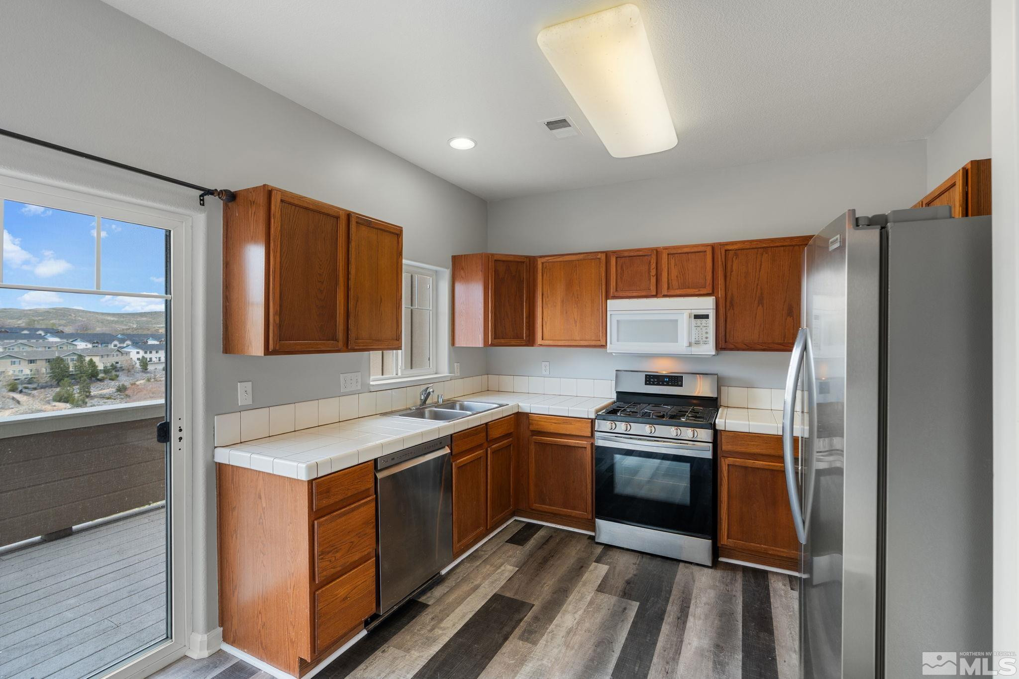 345 Madison Marie Lane Reno, NV 89503 - Photo 16 of 34 a kitchen with a sink stove and refrigerator
