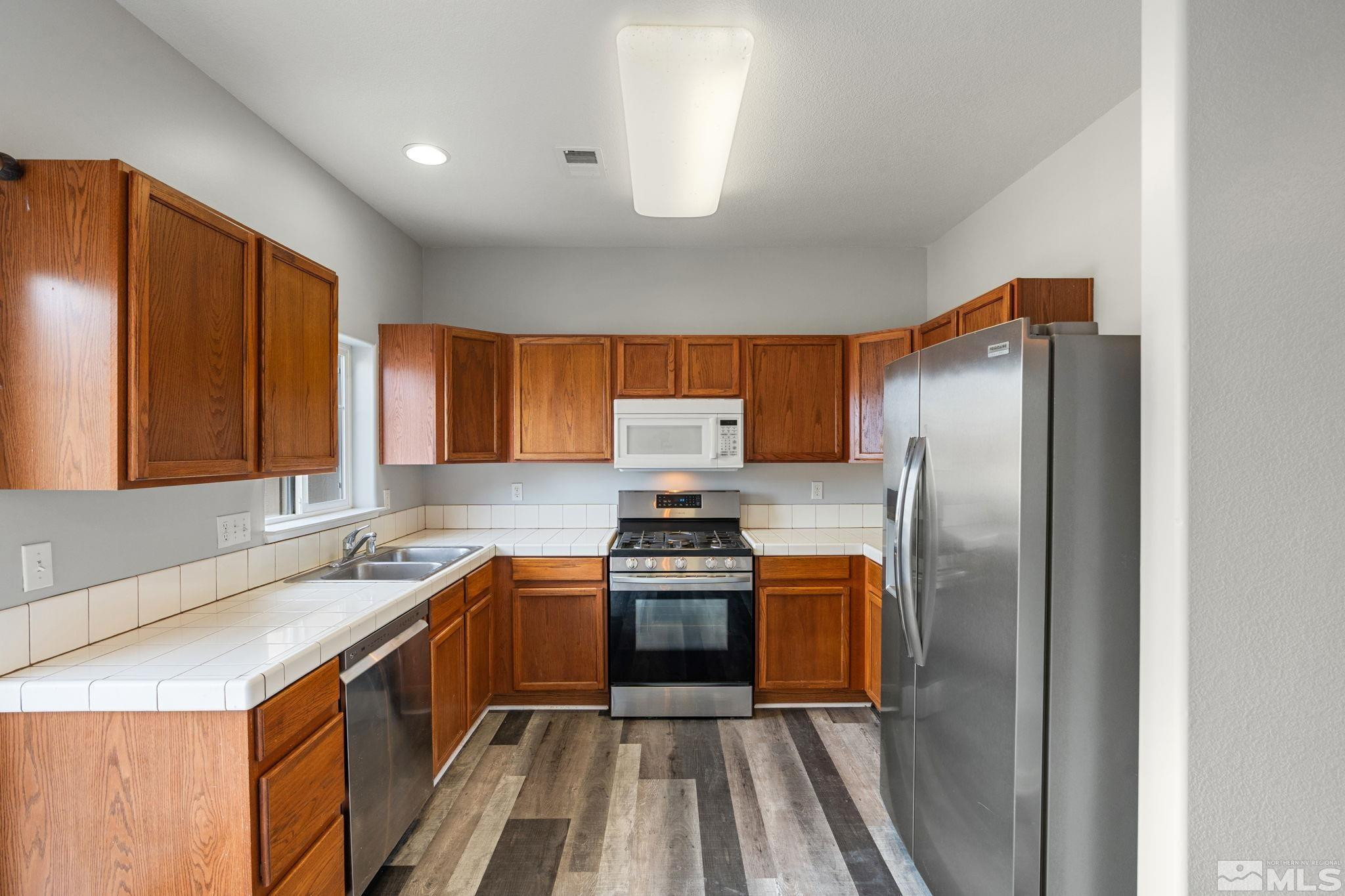 345 Madison Marie Lane Reno, NV 89503 - Photo 17 of 34 a kitchen with stainless steel appliances granite countertop a sink stove and refrigerator