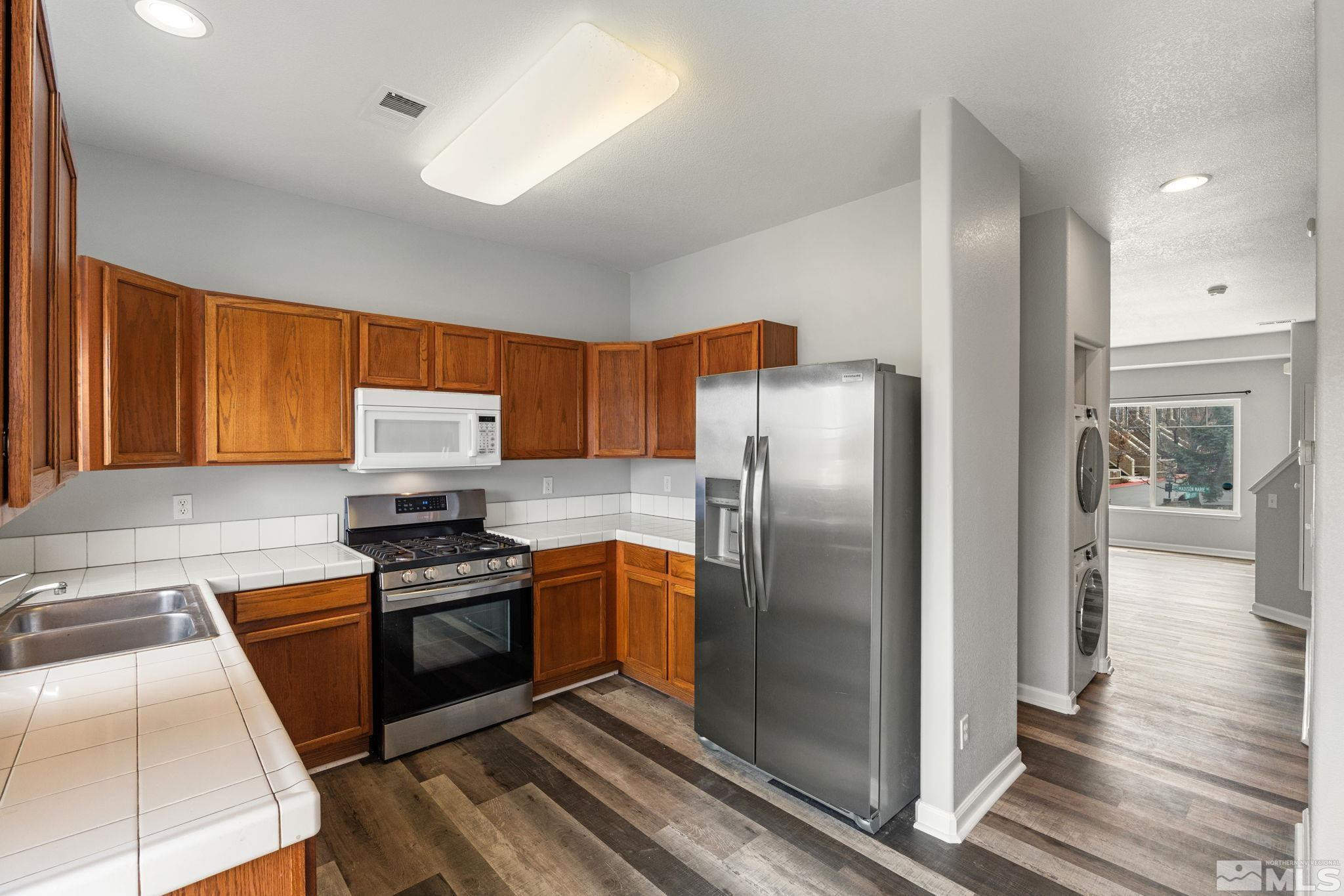 345 Madison Marie Lane Reno, NV 89503 - Photo 18 of 34 a kitchen with stainless steel appliances granite countertop a refrigerator stove and sink