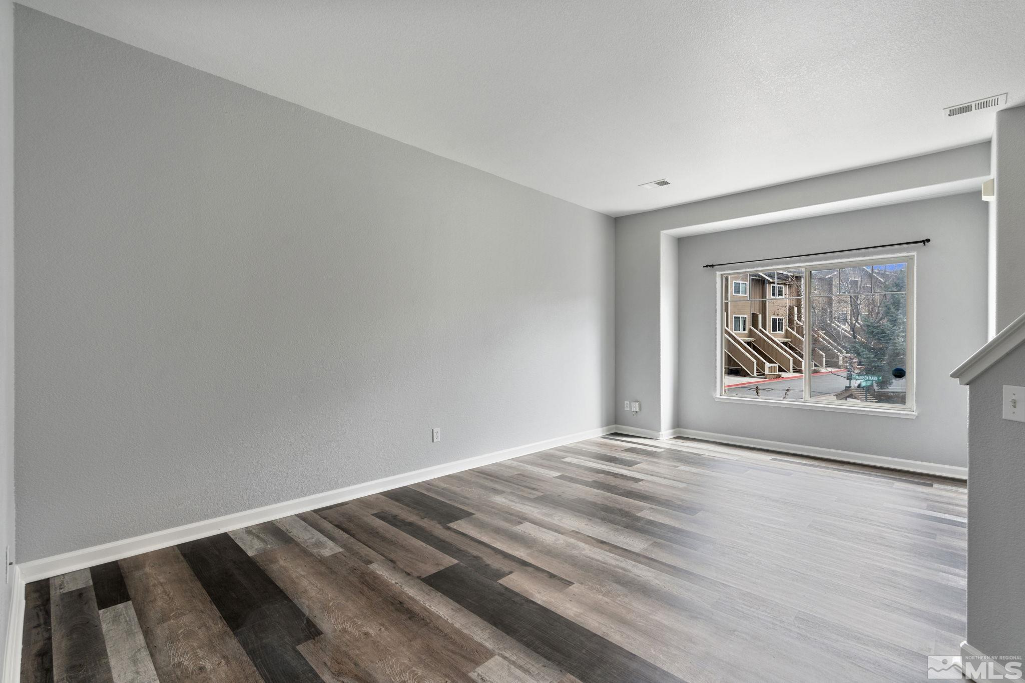 345 Madison Marie Lane Reno, NV 89503 - Photo 10 of 34 a view of an empty room with wooden floor and a window