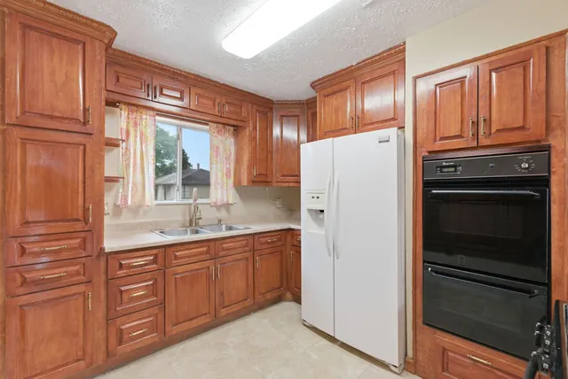 a kitchen with stainless steel appliances granite countertop a refrigerator and a sink