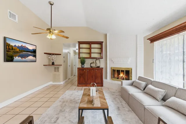 a living room with furniture a fireplace and a flat screen tv