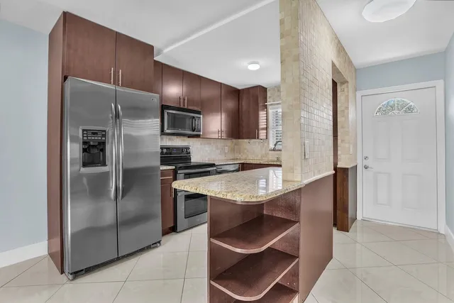 a kitchen with stainless steel appliances granite countertop a refrigerator and a sink