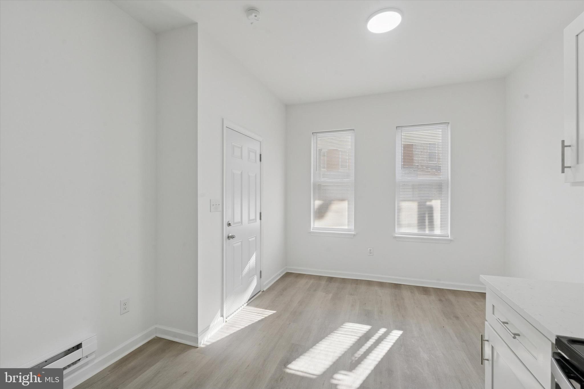3827 Cambridge Street, Unit 1 Philadelphia, PA 19104 - Photo 2 of 7 an empty room with wooden floor and windows