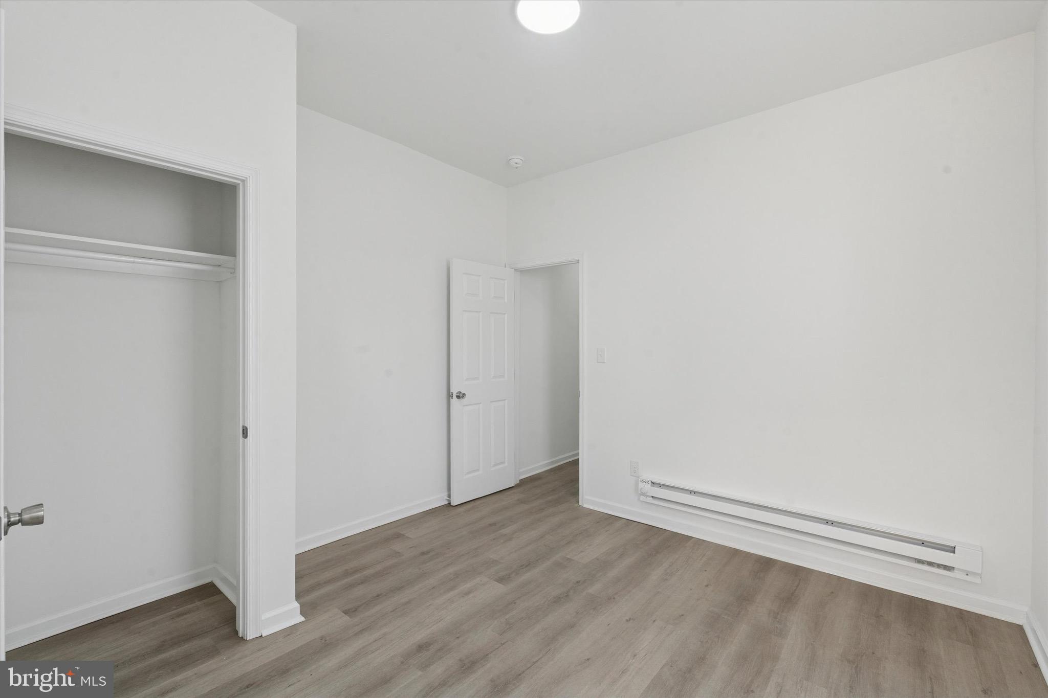 3827 Cambridge Street, Unit 1 Philadelphia, PA 19104 - Photo 6 of 7 an empty room with wooden floor and white walls