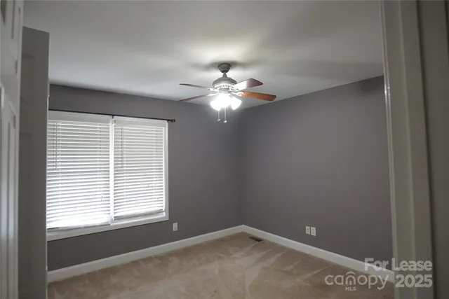 a view of a livingroom with a ceiling fan and window