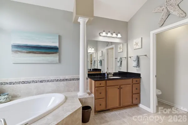 a spacious bathroom with a granite countertop sink and a mirror