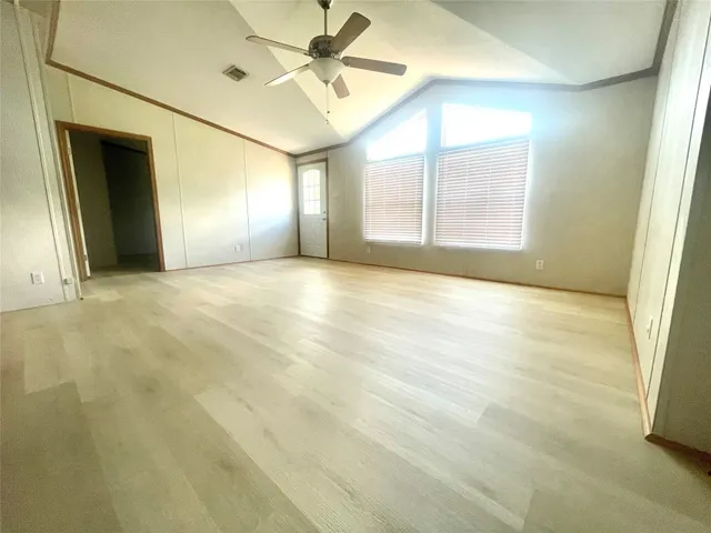 an empty room with windows and fan