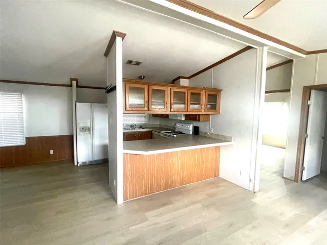 a view of a kitchen with stainless steel appliances a refrigerator and a stove
