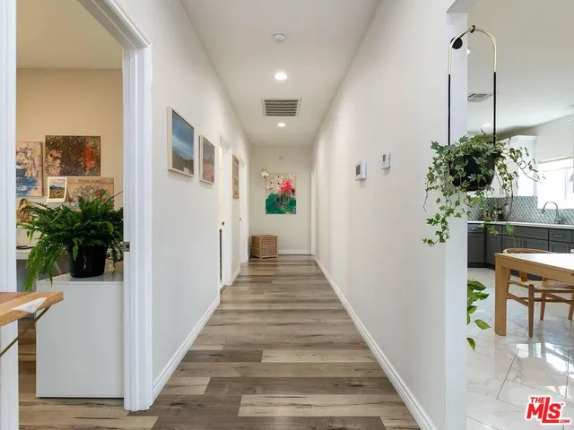 a view of a hallway with wooden floor and stairs