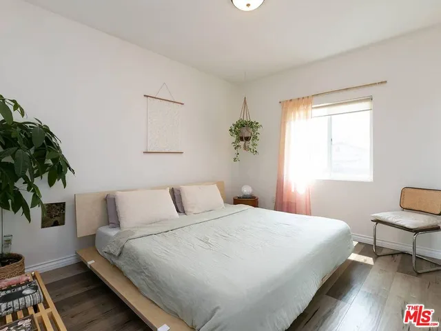a bedroom with a bed and a potted plant