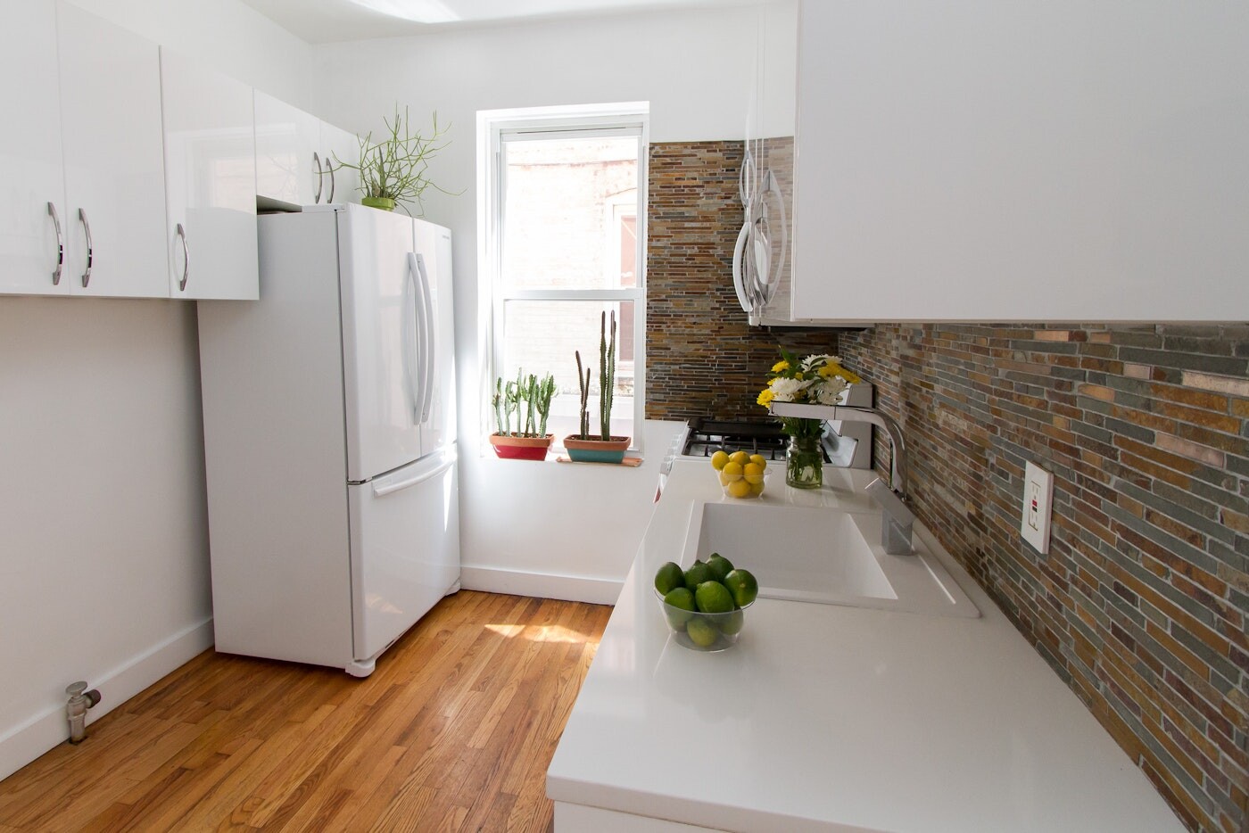 47-14 48th Street, Unit 1R Queens, NY 11377 - Photo 3 of 18 a kitchen with a refrigerator and a table
