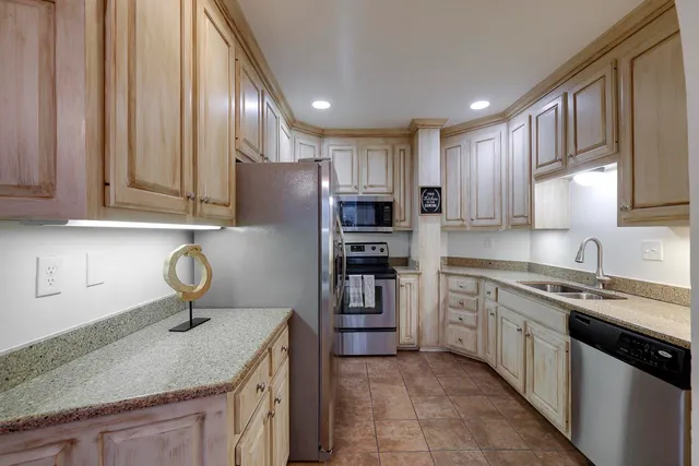 a kitchen with stainless steel appliances granite countertop a sink stove and cabinets