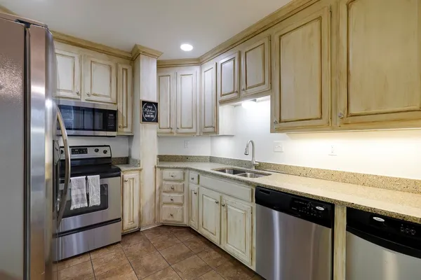 a kitchen with stainless steel appliances granite countertop a stove a sink and a microwave