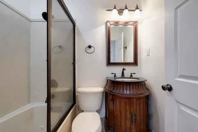 a bathroom with a toilet a sink and mirror