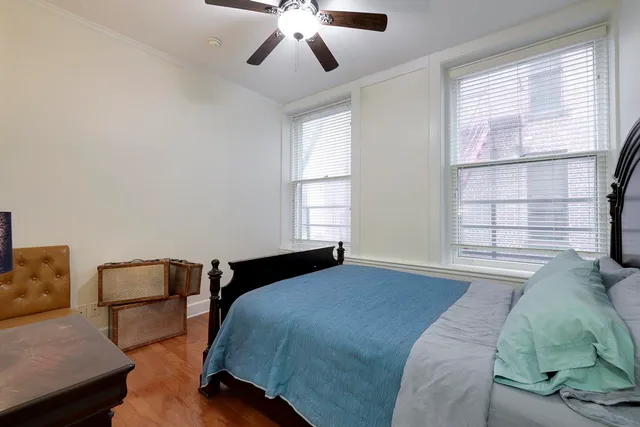 a bedroom with a bed and wooden floor