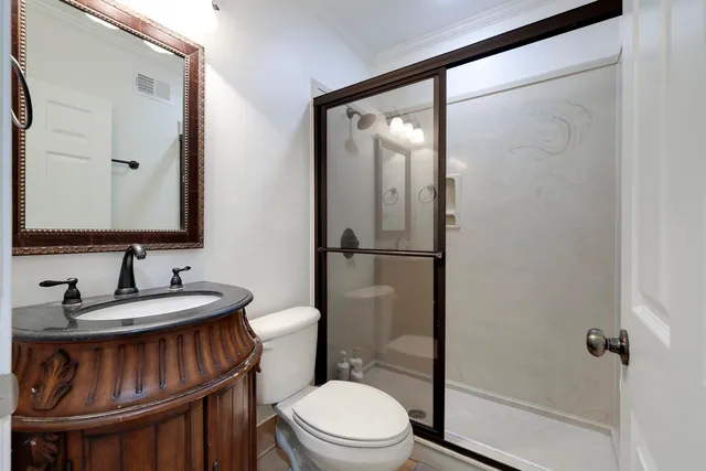 a bathroom with a sink toilet vanity and shower