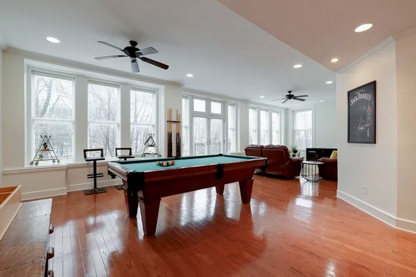a living room with furniture a large window and wooden floor