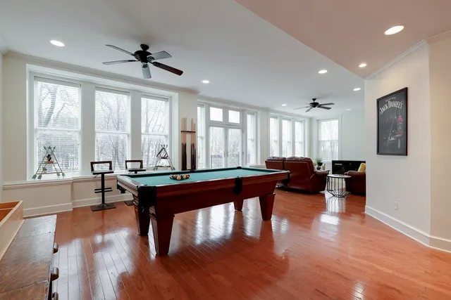 a living room with furniture a large window and wooden floor