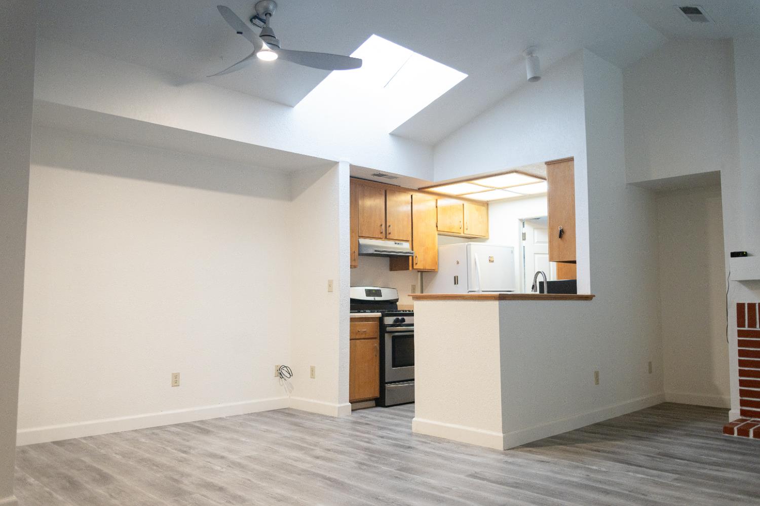 2263 Sandcastle Way Sacramento, CA 95833 - Photo 10 of 23 an empty room with wooden floor kitchen view and a window