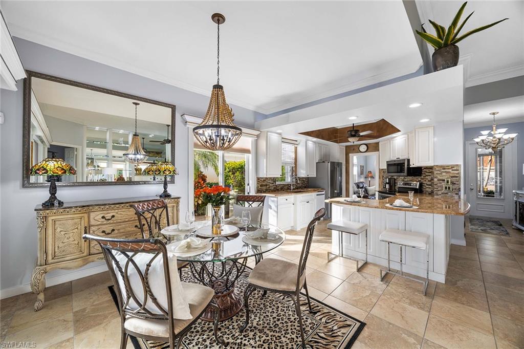 7534 Garibaldi Court Naples, FL 34114 - Photo 13 of 50 a view of a dining room and livingroom with furniture wooden floor a chandelier