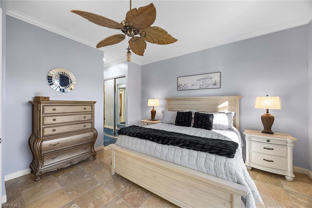 7534 Garibaldi Court Naples, FL 34114 - Photo 16 of 50 a bedroom with a bed and a chandelier