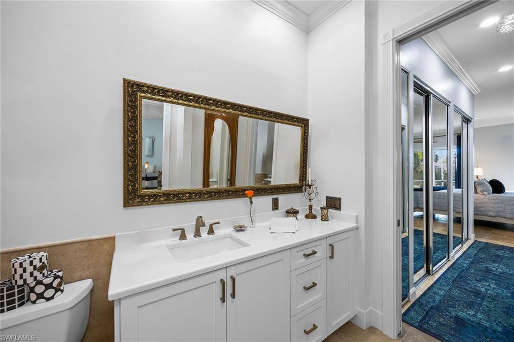 7534 Garibaldi Court Naples, FL 34114 - Photo 21 of 50 a bathroom with a sink a toilet and a mirror