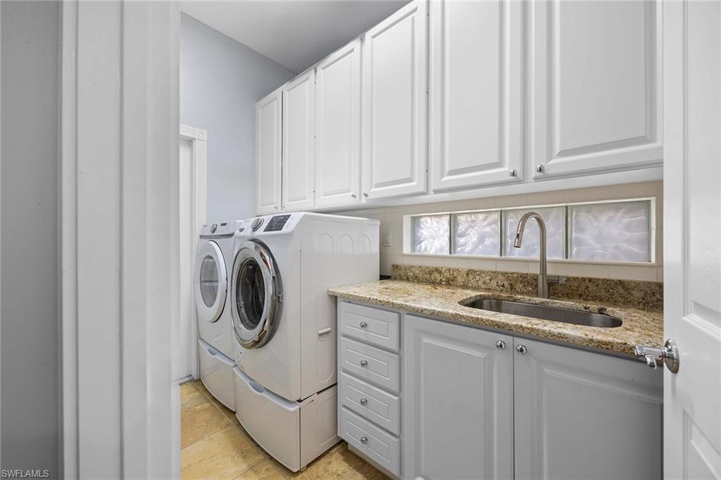 7534 Garibaldi Court Naples, FL 34114 - Photo 25 of 50 a utility room with granite countertop cabinets and washer