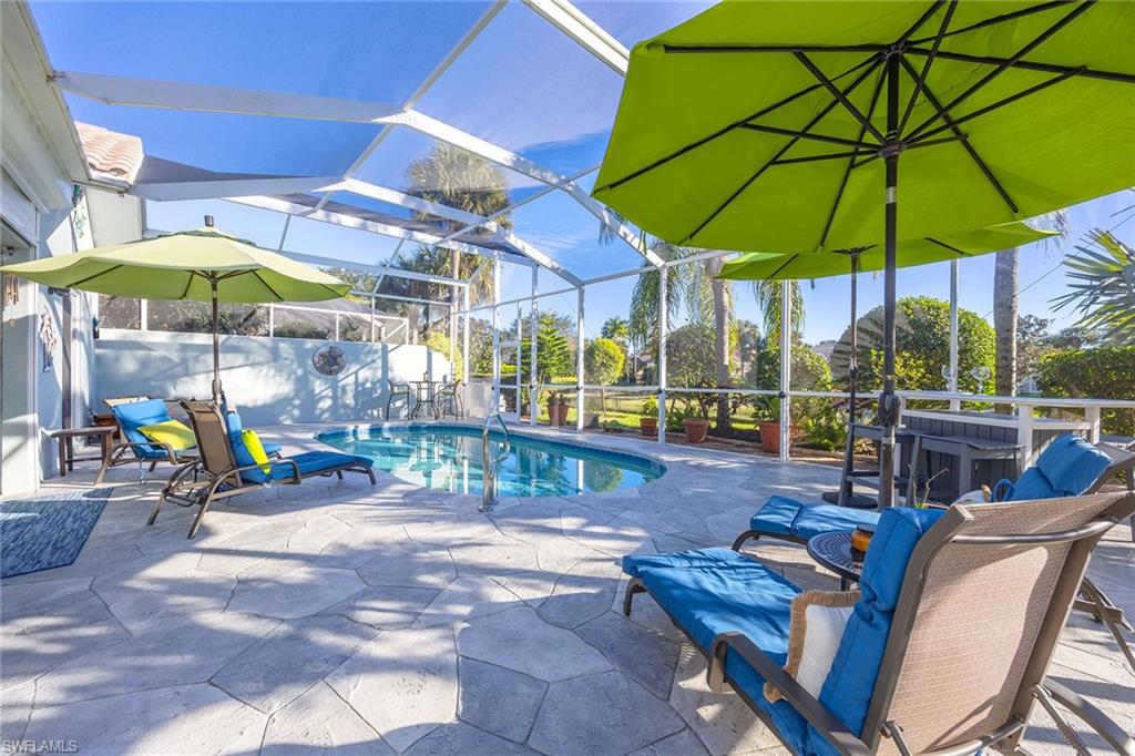7534 Garibaldi Court Naples, FL 34114 - Photo 32 of 50 a view of a patio with a table and chairs under an umbrella