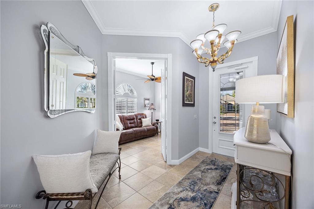 7534 Garibaldi Court Naples, FL 34114 - Photo 5 of 50 a living room with furniture a chandelier and a flat screen tv