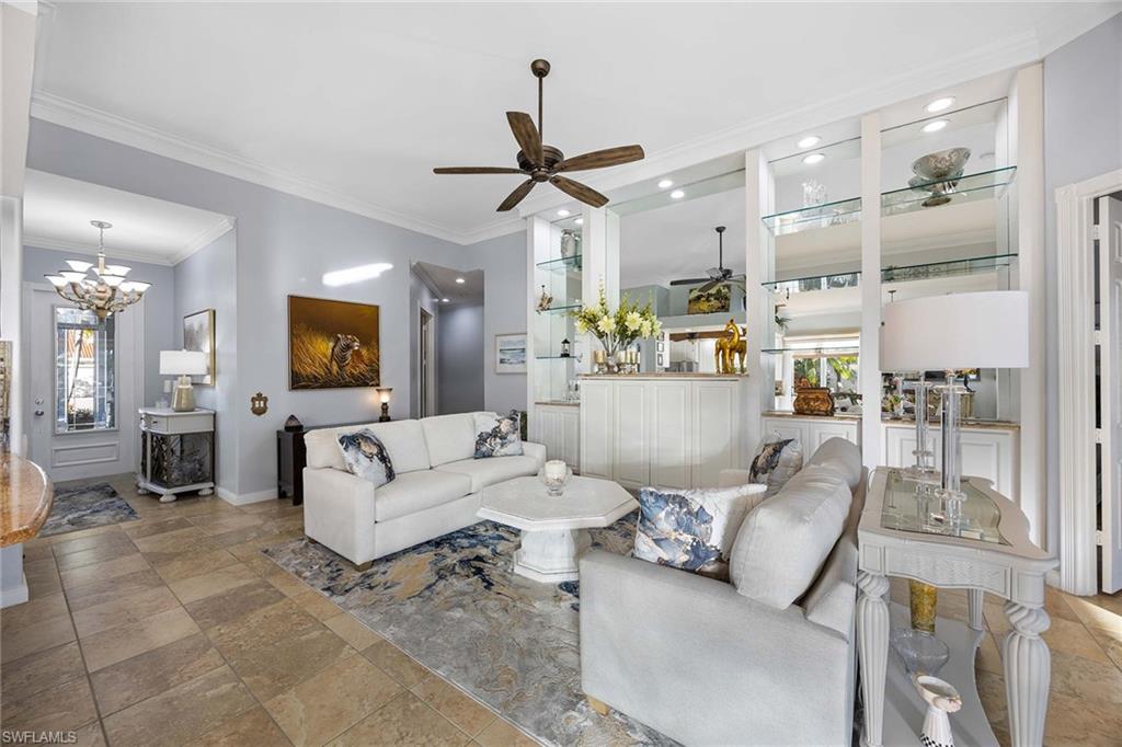 7534 Garibaldi Court Naples, FL 34114 - Photo 7 of 50 a living room with furniture and a chandelier