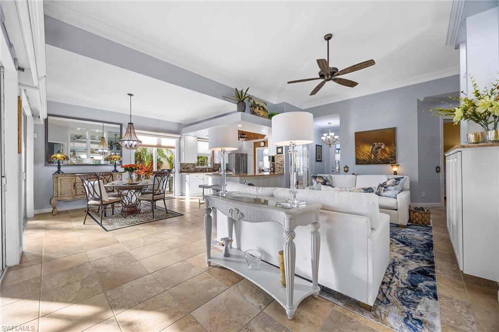 7534 Garibaldi Court Naples, FL 34114 - Photo 9 of 50 a living room with stainless steel appliances kitchen island granite countertop furniture and a chandelier