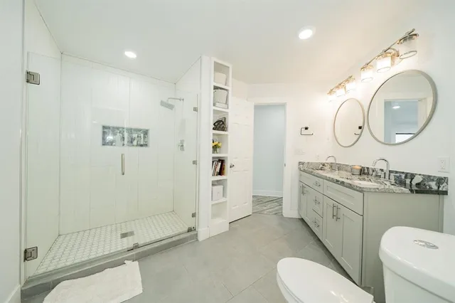 a spacious bathroom with a toilet a sink and a shower