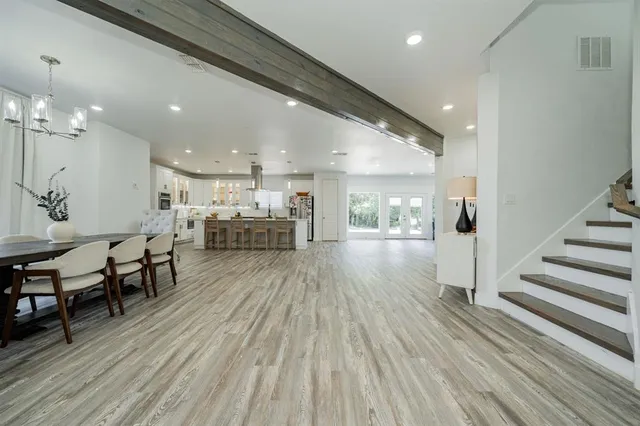 a view of a hallway with wooden floor and chairs
