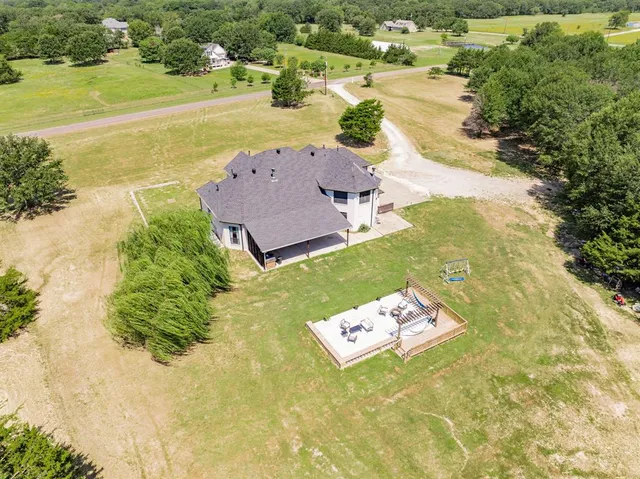 an aerial view of a house with a yard and lake view