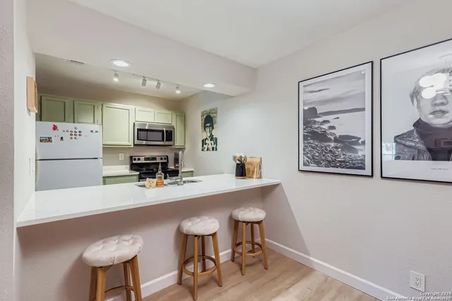 a kitchen with stainless steel appliances a refrigerator and microwave