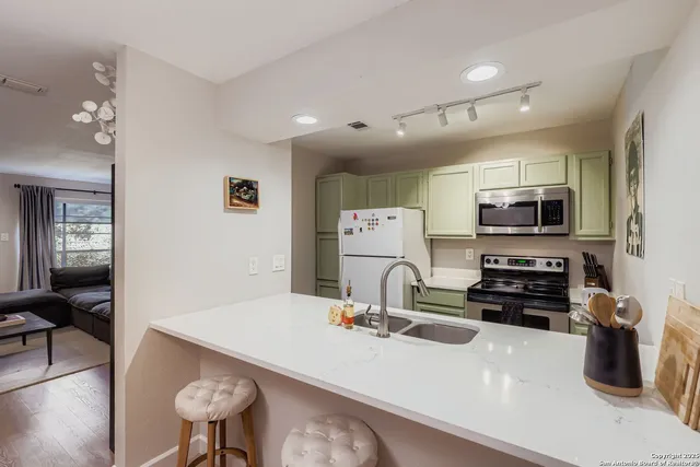 a kitchen with stainless steel appliances a sink and a refrigerator