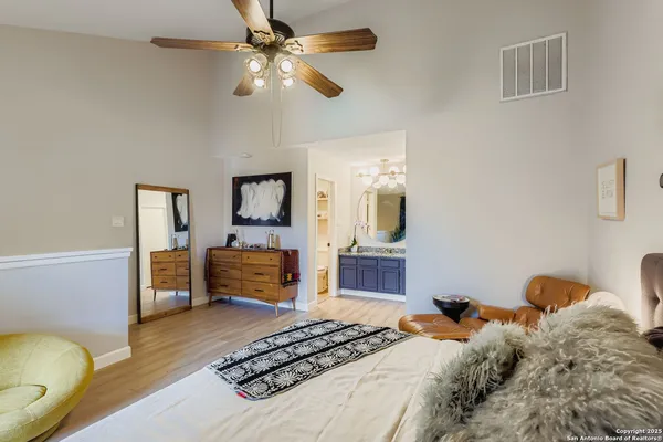 a bedroom with a bed dresser and wooden floor